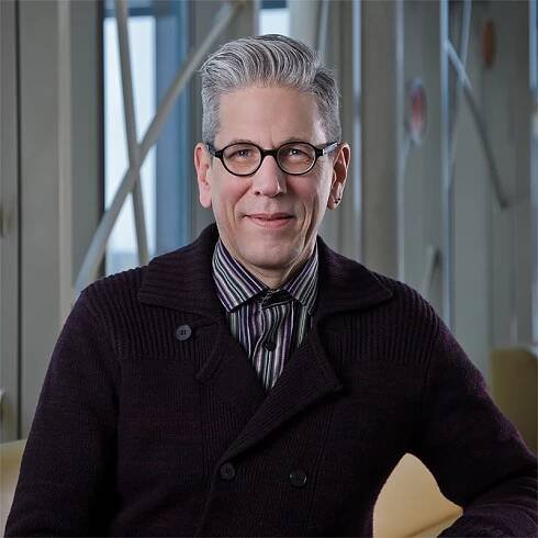 Professional photo of Mark Nelson in front of 100 Women Wall.