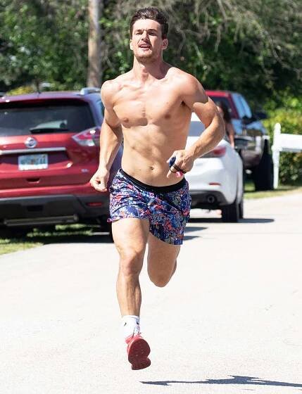 Tyler Cameron shows off his buff body as he runs with his dog in Florida.