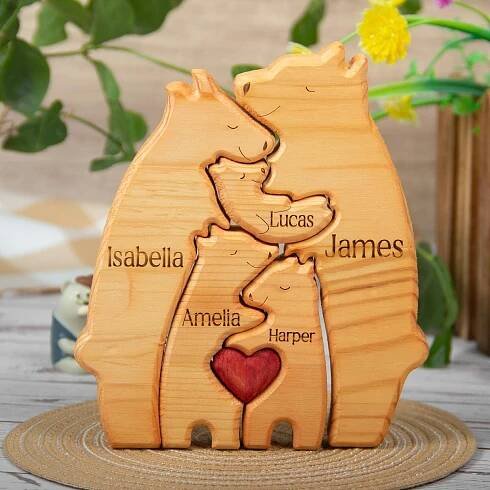 May include: A wooden family bear sculpture with a red heart in the center. The bears are stacked on top of each other and each bear has a name engraved on it: Isabella, Amelia, Harper, Lucas, and James.