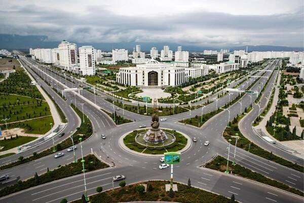 The Dutar monument (front) symbolizes inspiration in Turkmen, with the Turkmen State Institute of Culture in the back. 