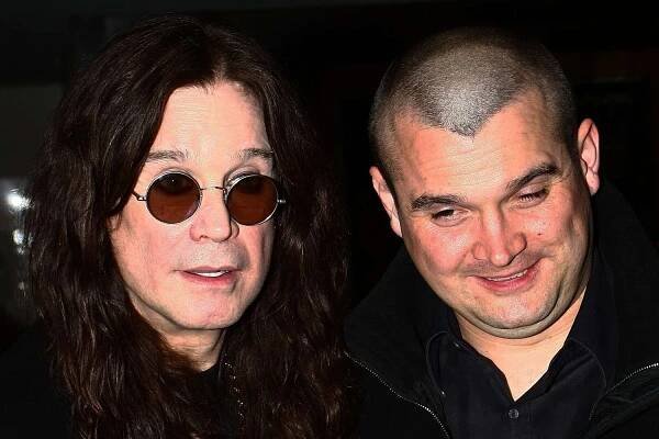 Ozzy Osbourne with another individual both looking at the camera