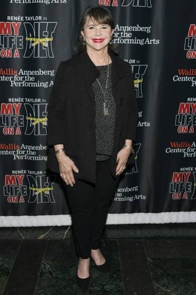 Cindy Williams poses in a black outfit with a red lip