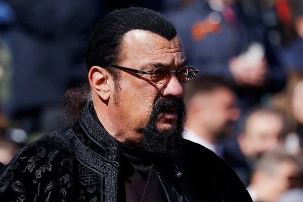 A close-up of Steven Seagal amid a crowd outside.