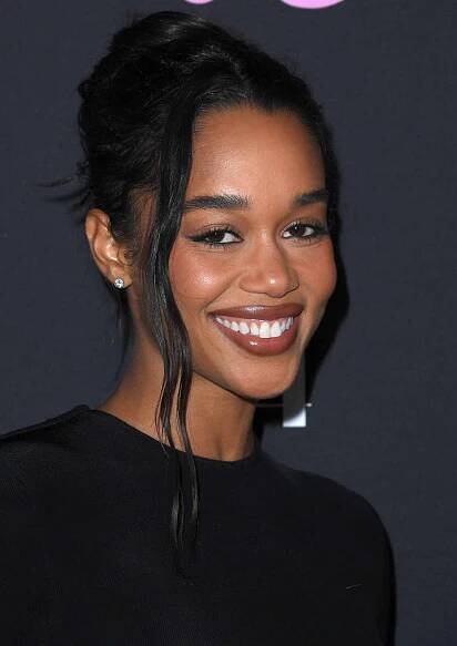 Laura Harrier smiles on a red carpet.