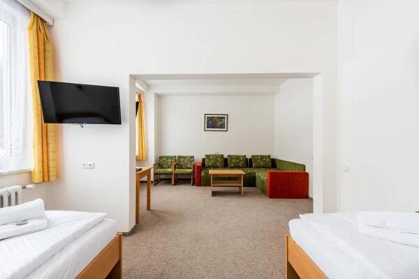 a room with two beds and a living room at HOTEL AGRI in Soběšice