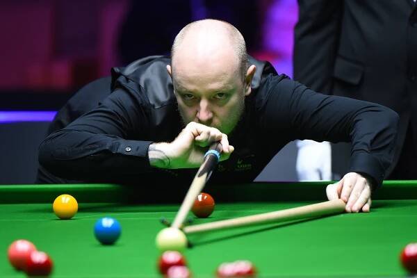 a man playing pool with a shirt that says king on it
