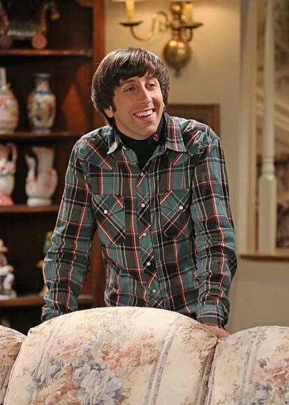the young man is smiling while sitting on a couch