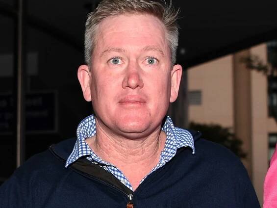John Norman, wearing blue jumper, looks straight to camera while walking outside at night