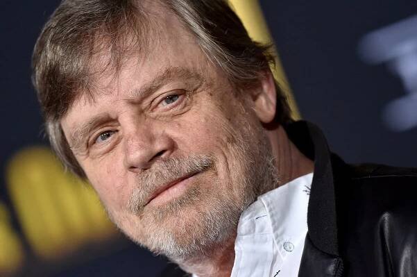 Mark Hamill taking a picture at the premiere of 'Knives Out'.