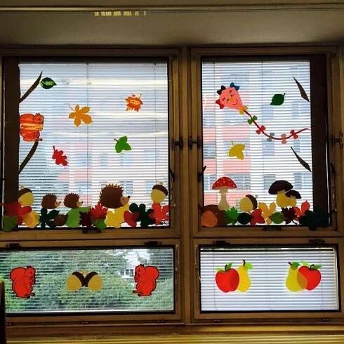 the window is decorated with apples, mushrooms, and other autumn themed items on it
