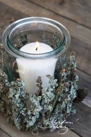 a lit candle is sitting in a glass jar