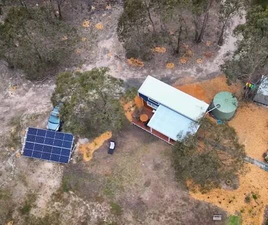 Aerial shot of the couple's tiny home, showing the huge solar panel and water tank.