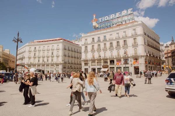 People walking around large buildings in Puerto del Sol