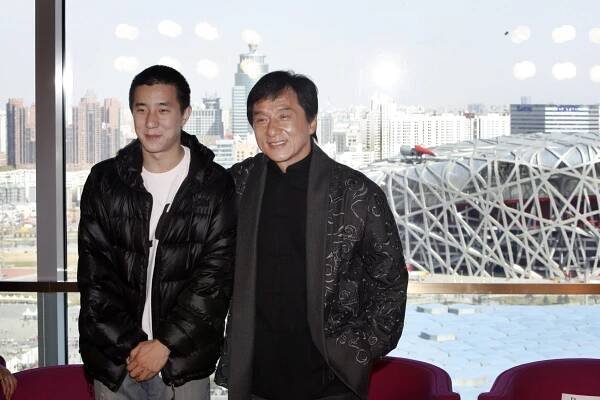 Jackie Chan posing with his son, Jaycee Chan, for a photo.