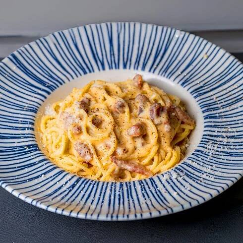Free Tasty spaghetti carbonara with pancetta and creamy sauce served on a plate. Stock Photo