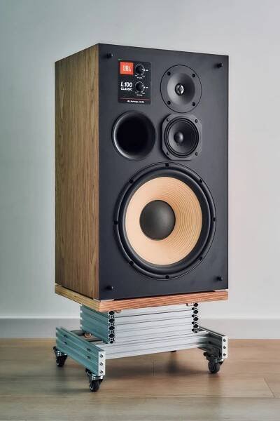 a large speaker sitting on top of a wooden stand