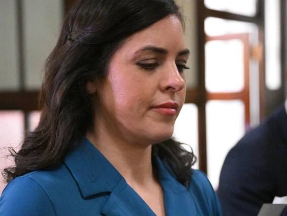 Liberal party MP Moira Deeming exits from a joint party meeting, wearing a blue dress.
