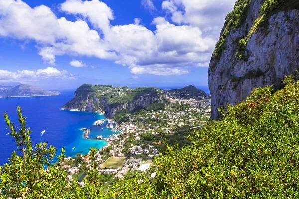 View of Capri from above on a sunny day. You can see buildings and the beaches.