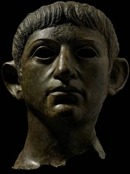Copper alloy head of the emperor Nero, from a life-size statue. The face is heart-shaped, with a strong chin and nose, large, slightly slanting eyes and prominent low-set ears.
