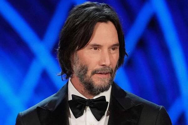 Keanu Reeves gets blindsided by an actor who climbed on top of his seat on live TV