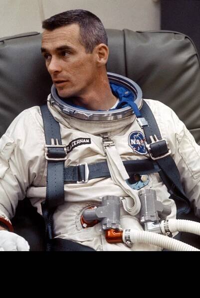 Gene Cernan sits in an armchair with his space suit