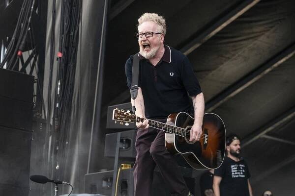 Dave King of Flogging Molly plays an acoustic guitar and sings onstage