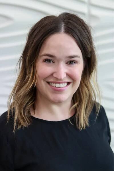 A profile picture of Allison Gordon in front of a white wall with a raised wave pattern.