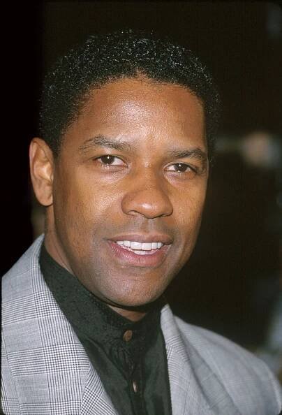 Denzel Washington standing on a red carpet