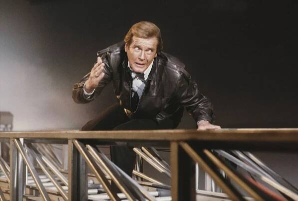 A matte shot of English actor Roger Moore as 007, clinging to a fire engine ladder in a publicity still for the James Bond film 'A View To A Kill', 1984