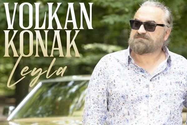 Turkish singer Volkan Konak wearing sunglasses and a patterned shirt, standing in front of a car in a wooded area. Album title Leyla and his name appear on the left side of the image.