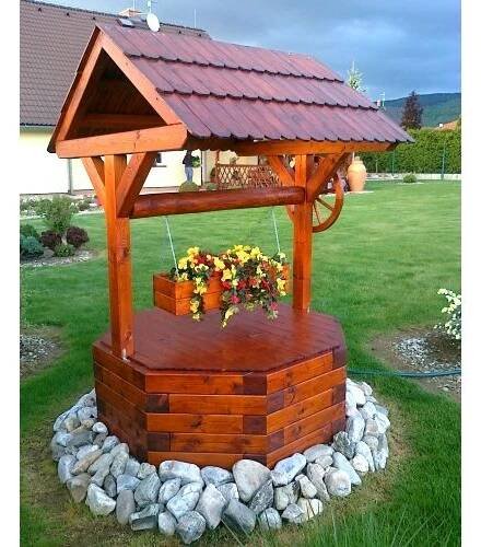 a wooden gazebo sitting on top of a lush green field