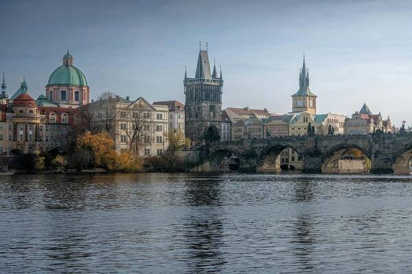 bezplatná Krásný výhled na Karlův most a historickou pražskou architekturu na pozadí klidné řeky. Základová fotografie
