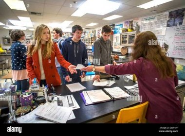 A high school chemistry teacher returns graded homework papers to her advanced placement (AP) students in San Clemente, CA Stock Photo