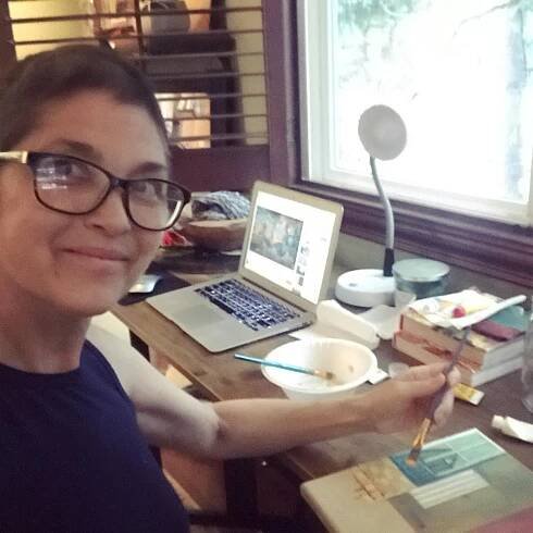 A selfie of Nicki Aycox sitting at a desk.
