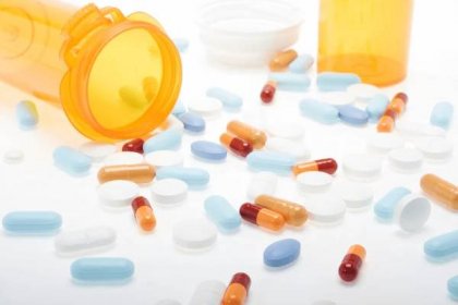 Stáhnout - Skladem obrázek tablety, kapsle a tablety různých barev, přes bílý, zaměření na popředí — Stock obrázek