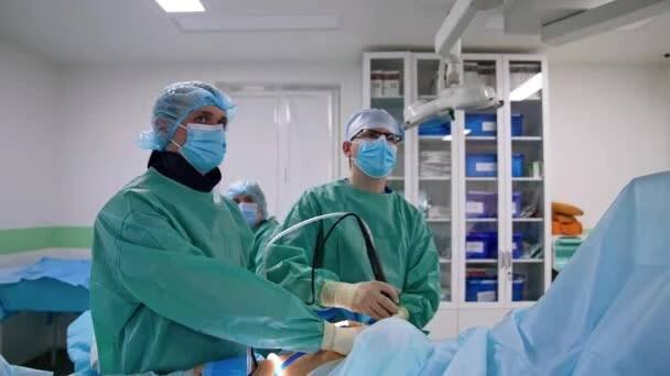 Profesionální chirurgové používají pokročilé laparoskopické chirurgické přístroje. Lékaři se zaměřují na monitor před nimi. — Stock záběr