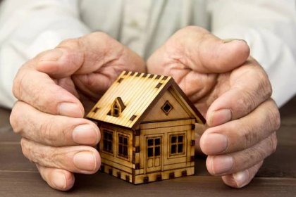 starý muž chránící model domu rukama. pojištění rizik. koncept hypoték a bankovních úvěrů. chudoba. pronájem nemovitosti. - elderly home - stock snímky, obrázky a fotky