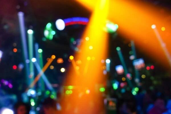 Defokussierter Hintergrund mit abstraktem Bokeh der Lasershow in einem modernen Disco-Party-Nachtclub - Nachtlebenskonzept mit Musik und Unterhaltung - Bild mit verbesserten farbigen Heiligenscheinen und lebendigen hellen Lichtern — Stockbild