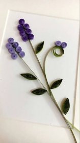 a card with purple flowers on it and green leaves attached to the back of it