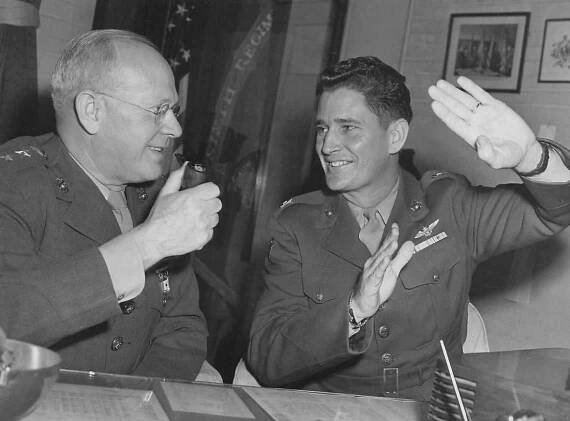 Publicity photo of General Holcomb being briefed on fighter tactics by Joe Foss