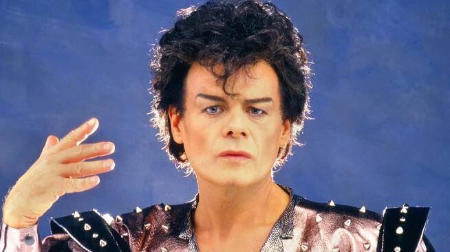 gary glitter backlit holding up hand