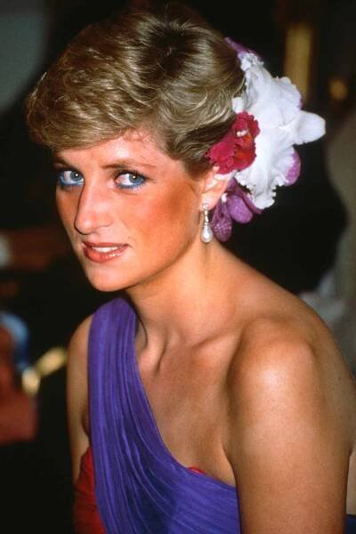 Diana, Princess of Wales, wearing a red and purple chiffon evening dress designed by Catherine Walker with silk flowers in her hair, attends a dinner on February 04, 1988 in Bangkok, Thailand.