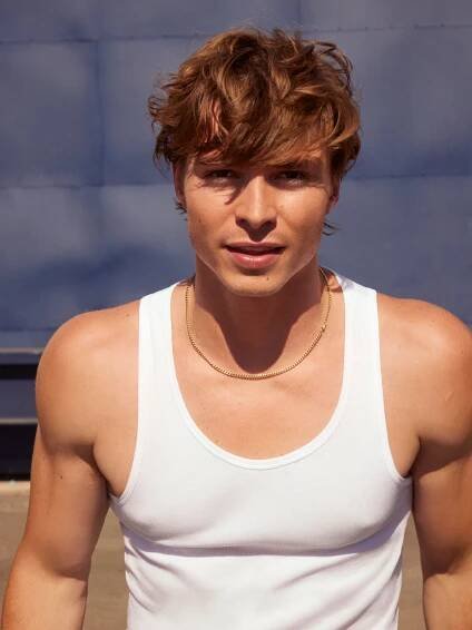 Nicholas Alexander Chavez looking directly to camera wearing a white tank top.