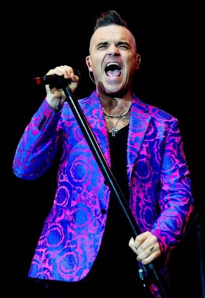 Robbie Williams performing on stage.