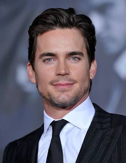 a close up of a person wearing a suit and tie