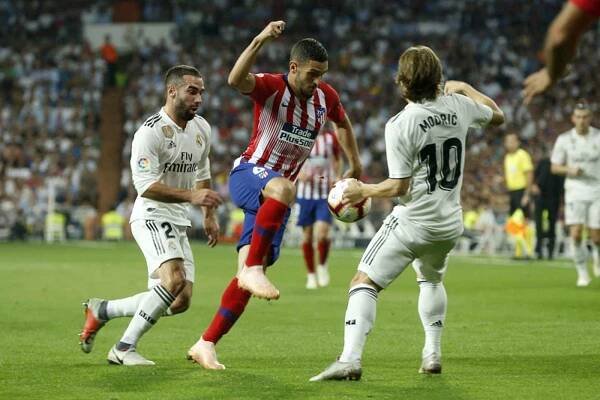 Fotbalista Atlética Madrid Koke (uprostřed) a hráči Realu Luka Modrič (vpravo) a Dani Carvajal v utkání španělské ligy.