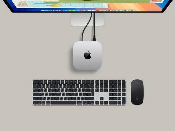 Front view of silver Mac mini showing front ports, with carbon neutral story illustrated by small green accents.