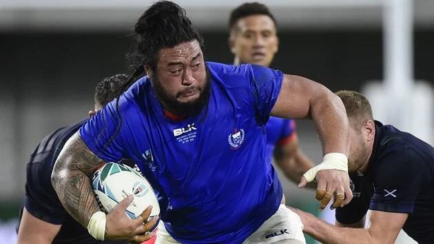 Rojník Logovi'i Mulipola ze Samoy se probíjí obranou Skotska v utkání na mistrovství světa.