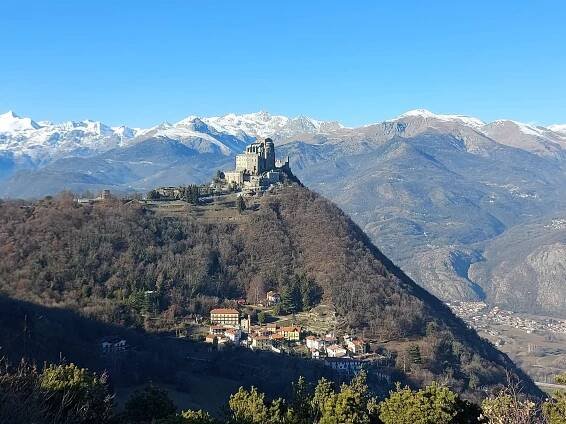 Die imposante Abtei Sacra di San Michele ist ein wichtiger Bestandteil einer 2-tägigen Piemont-Rundreise. Das Kloster thront hoch über dem Val di Susa, und im Hintergrund sind die schneebedeckten Alpengipfel zu sehen.