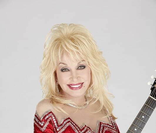 Dolly Parton in a red sequined dress, holding a guitar.
